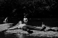 man-lays-on-rocks-BnW