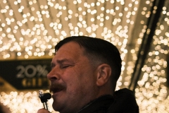 Our-mate-singing-outside-shop-portrait-beneath-the-lights