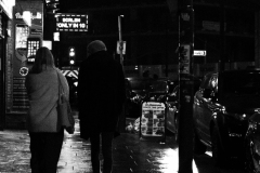 couple-walks-past-phone-repair-shop-BnW