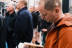 man-holds-book-amidst-crowd-Tram-stop